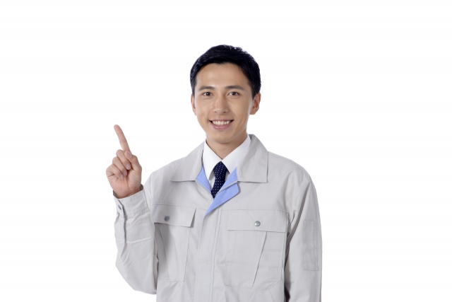 指を指す作業服の男性